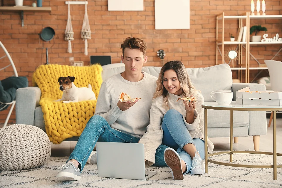 A young couple relaxing on the sofa with their dog